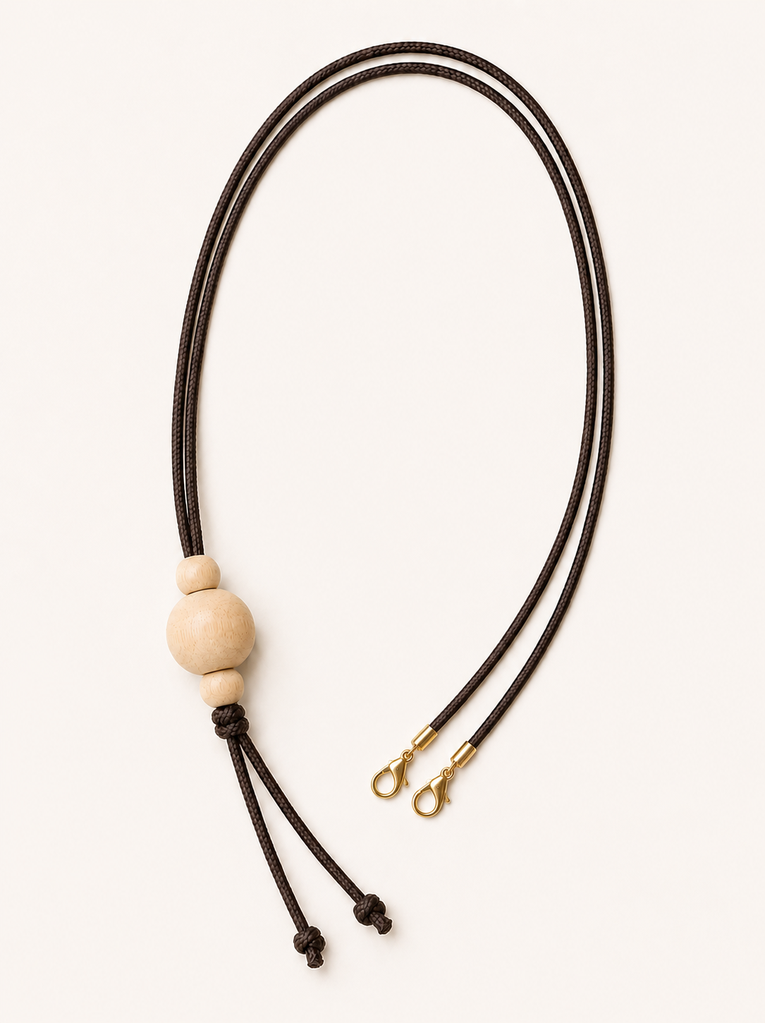  a wooden bead and  with a brown cord and a gold clasp on a white background