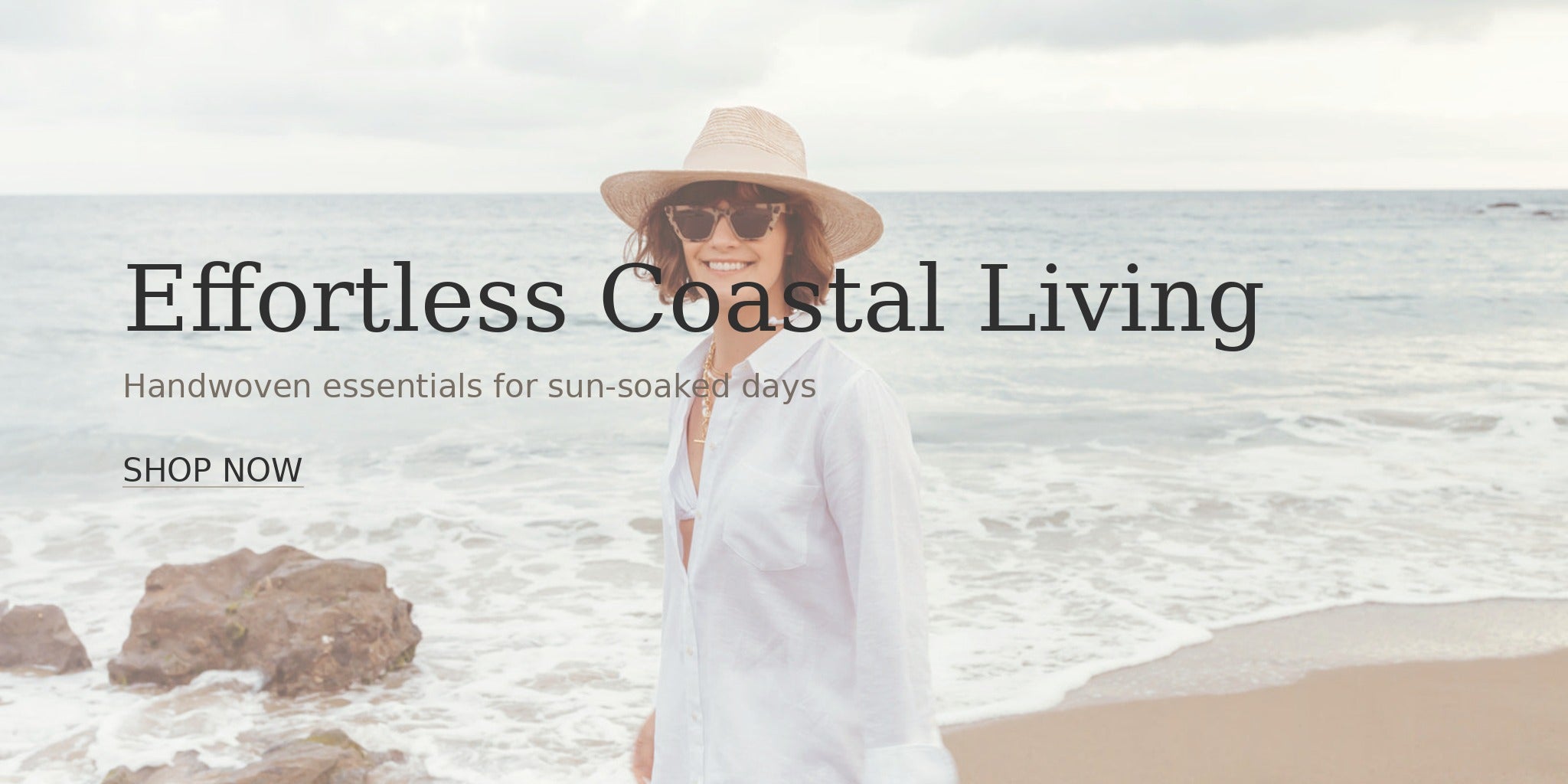 Woman in a white dress and hat standing on a beach with text overlay 'Effortless Coastal Living'.