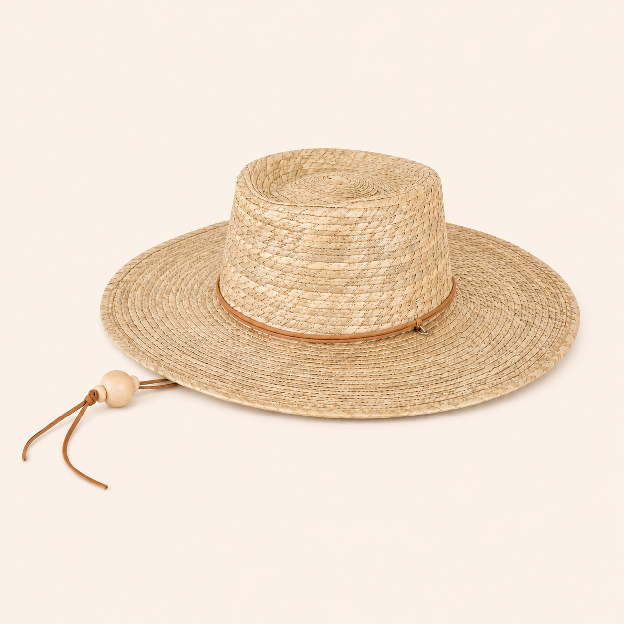 Beige straw hat with a wide brim on a beige background