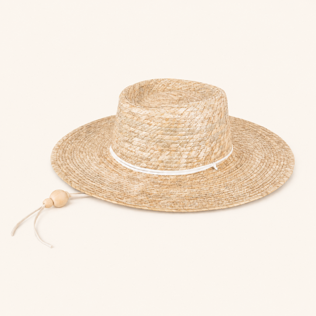 Beige straw hat with a white band on a light beige background
